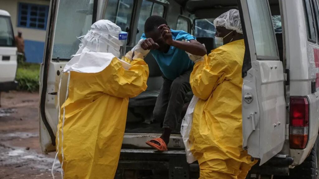 Médicos de la Cruz Rojo sacan de camioneta a infectado por brote de Ébola en Africa.