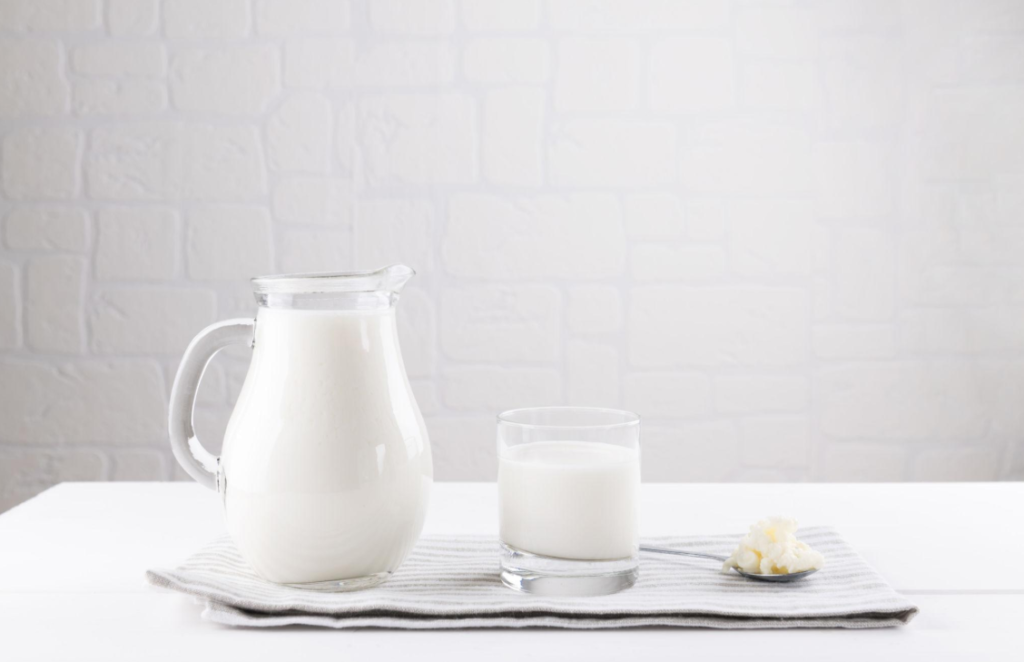 Que es la microbiota intestinal en una jarra de yogur, un vaso de yogur y nódulos de kéfir