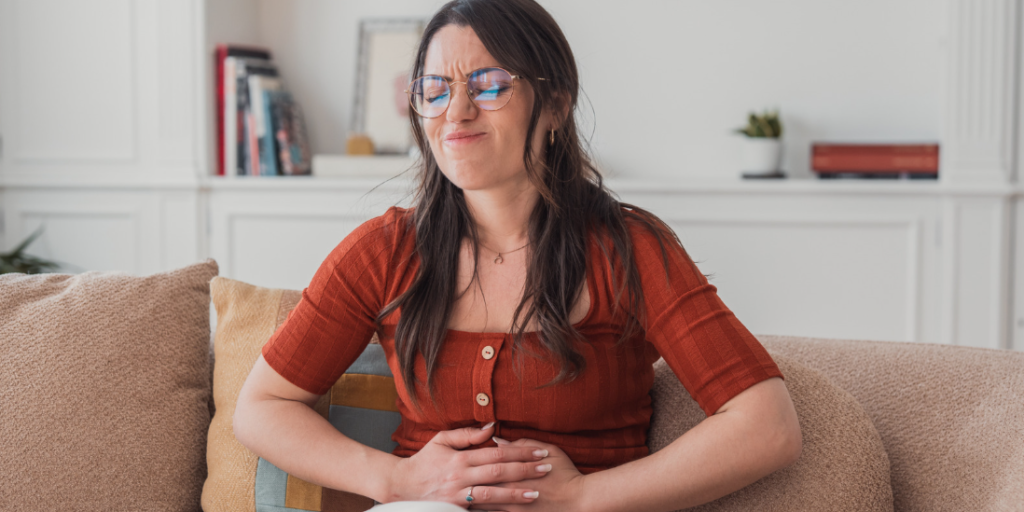 Mujer con expresión de dolor en su casa por helicobacter pylori después del tratamiento