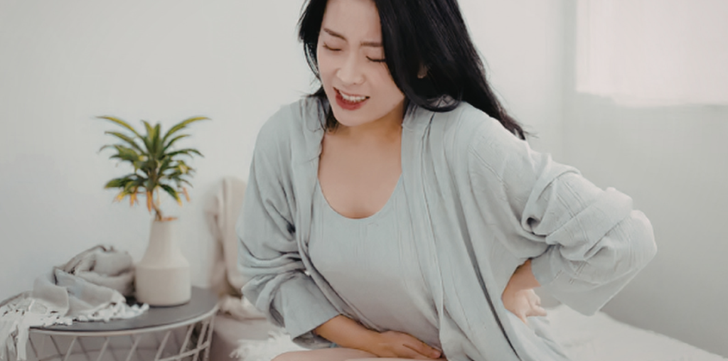 Mujer sentada en mueble con ardor después del tratamiento de Helicobacter pylori